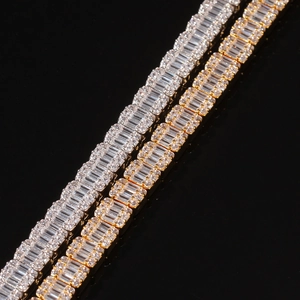 Macro shot of gold and silver hip-hop bracelets with baguette and round cut zircons