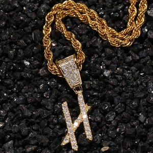 Macro detail of iced-out letter H pendant with zircon stones on golden rope chain necklace