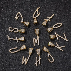 Macro shot of gold plated cursive letters pendants with pave set zircon stones