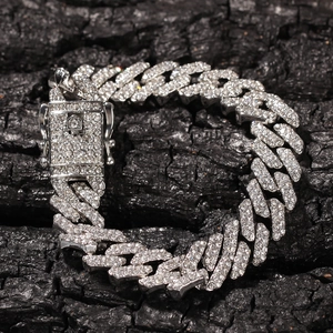 Detail der versilberten Iced Out Kuba-Kette mit quadratischem Verschluss auf Holzkohle