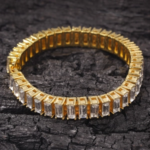 Macro shot of gold-plated tennis necklace with rectangular baguette-cut zirconia stones