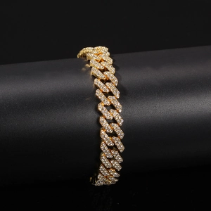 Nahaufnahme eines vergoldeten Cuban-Link-Armbands mit Strass auf schwarzem Display