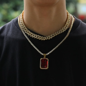 Detail der gelagerten goldenen kubanischen Kette und Halskette mit rotem Anhänger