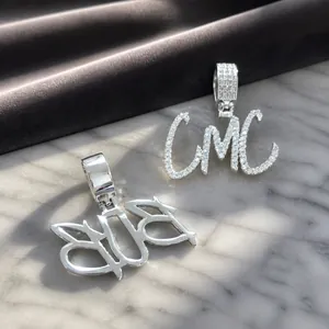 Macro shot of silver hip hop letter pendants with pavé zircon and polished finish