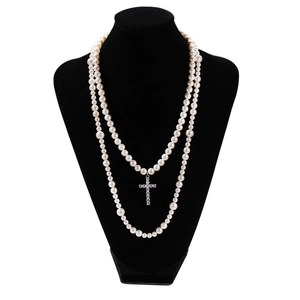Detalle de collar de perlas de doble capa con un colgante de cruz de circonita