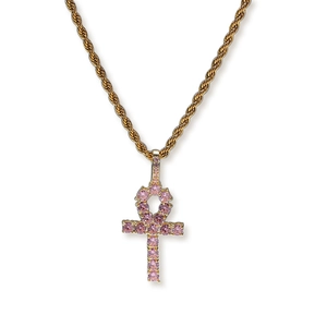 Close-up of golden Ankh key cross pendant with pink zircon stones on rope chain