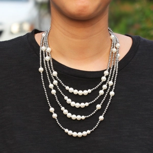 Dettaglio della collana a quattro strati stile street con sfere d'argento e perle