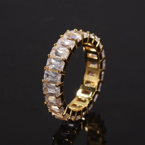 Macro shot of hip hop eternity ring featuring emerald cut zircons and gold plating