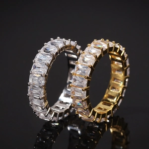 Detail of hip hop eternity rings featuring emerald-cut cubic zirconia in gold and silver