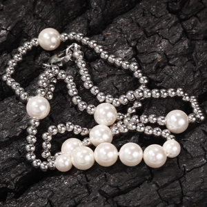 Collana stile hip hop con sfere d'acciaio argento e perle bianche su legno scuro