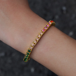 Macro detail of 4mm gold tennis bracelet with multi-color rhinestones and pavé setting