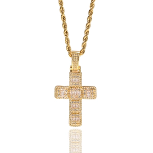 Détail du pendentif croix dorée hip hop serti de zircons sur une chaîne corde