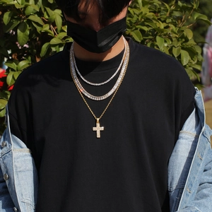 Photo en plein air d'un ensemble bijoux hip hop avec pendentif croix et chaînes