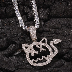 Macro shot of silver hip-hop tennis chain with a pavé-set devil face pendant on dark stone