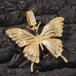 Makroaufnahme von Gold Schmetterling Anhänger mit Zirkonia auf dunklem Holzhintergrund