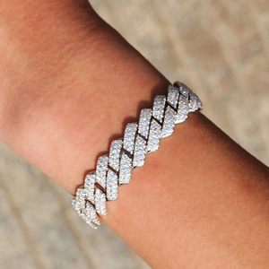 Gros plan d'un bracelet gourmette cubaine hip hop serti de zircons porté au poignet