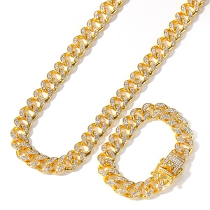 Detail view of 13mm gold plated iced out Cuban link necklace and bracelet set with zircons