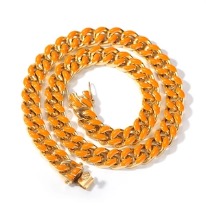 Détail d'une chaîne cubaine de 12 mm avec inserts en émail orange et finition dorée