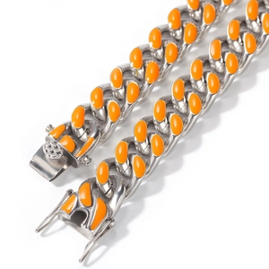 Gros plan d'une chaîne cubaine de 12 mm avec maillons argentés et émail orange vif décoratif