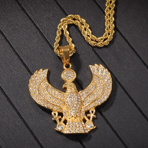 Macro shot of gold-plated Egyptian eagle pendant encrusted with sparkling rhinestones