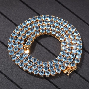 Macro detail of 4mm gold tennis chain featuring light blue pavé-set cubic zirconia stones