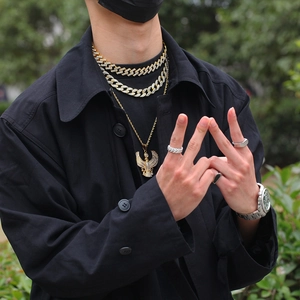 Detail of hip hop Cuban link chains, eagle pendant, and luxury watch on male model