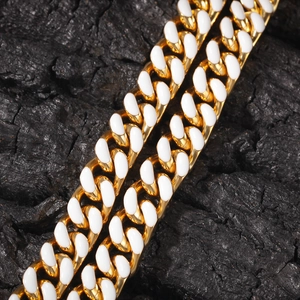 Détail d'une chaîne cubaine de 12mm dorée avec incrustations d'émail blanc élégant