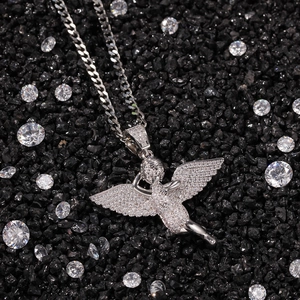 Macro detail of iced-out hip hop angel pendant with cubic zirconia stones on Cuban chain