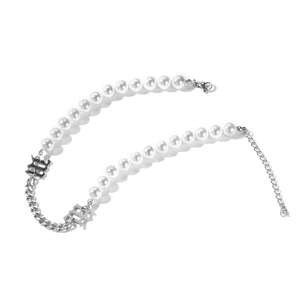 Dettaglio della collana con perle e catena argentata con ciondoli gotici e chiusura a moschettone