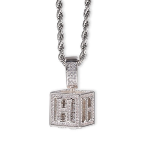 Gros plan du pendentif dé hip-hop argenté avec lettre H et pavé de zircons cubiques