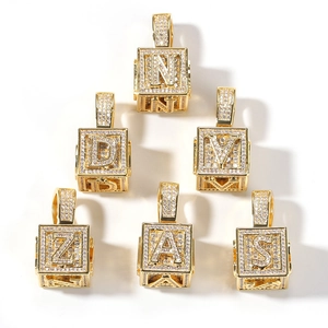 Gros plan détaillé de six pendentifs hip hop dorés avec lettres pavées de zircons brillants