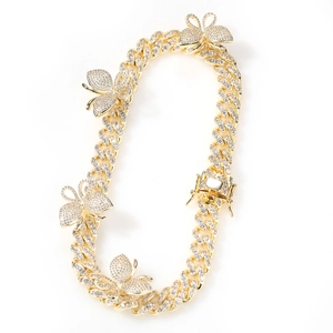 Detail of gold Cuban link chain with iced out butterfly charms and double lock clasp
