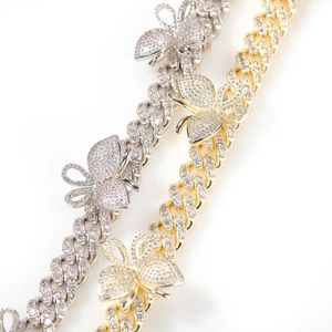 Close-up of gold and silver butterfly Cuban link necklaces with micro-paved cubic zirconia