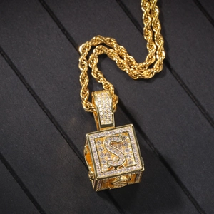 Détail du pendentif cube doré avec lettre S et zircons sur une chaîne torsadée