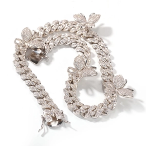 Close-up of silver Cuban link chain with micro-pave butterfly pendants and iced out zircons