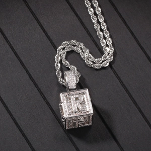 Détail du pendentif dé hip-hop avec oxydes de zirconium et lettre R sur chaîne corde