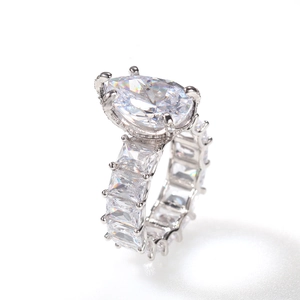 Macro view of pear cut diamond ring with rectangular side stones in silver band