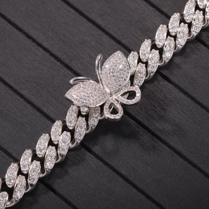 Close-up of hip-hop silver Cuban link chain with detailed micro-pave butterfly charm