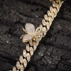 Macro view of iced-out gold Cuban chain with detailed micro-pave butterfly pendant