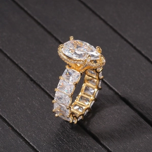 Detailed close-up of golden pear-shaped drop ring with clear eternity square cubic zirconia
