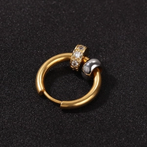 Détail de créoles dorées avec roue en zircone pavée et pendentif sphérique gris fusil