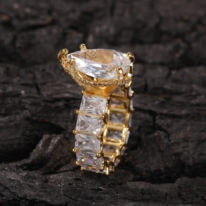 Macro side view of a luxury gold pear-shaped zircon ring with rectangle pave band detail