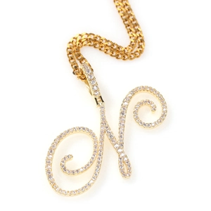 Détail du pendentif lettre N dorée serti de zircons sur une chaîne cubaine plate
