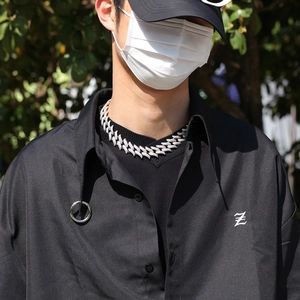 Close-up of 20mm iced out Cuban link chain necklace worn by a male model outdoors