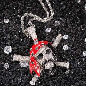 Macro shot of micro-pave skull pendant with red enamel headband and silver rope chain