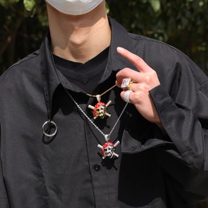 Detailed shot of hip hop pirate skull pendants with zircon stones on a male model