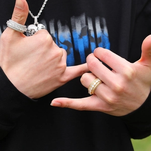 Dettaglio di anelli hip hop rotanti in oro e argento con zirconi cubici brillanti