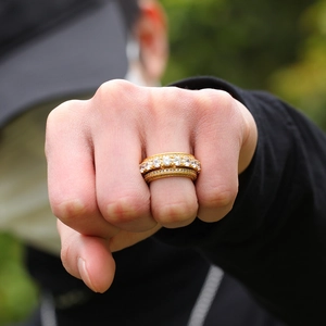 Dettaglio dell'anello hip hop rotante placcato oro con castone di zirconi rotondi