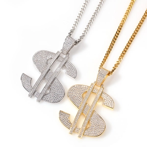 Macro shot of silver and gold dollar sign pendants encrusted with cubic zirconia stones