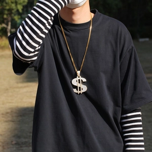 Close-up of hip hop gold dollar sign pendant with cubic zirconia on a cuban link chain